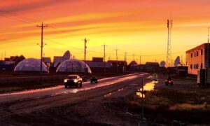 This beautiful photo shows the community of Arviat Nunavut as the sun sets in front of two Arctic greenhouses. Photo by Tony Eetak.